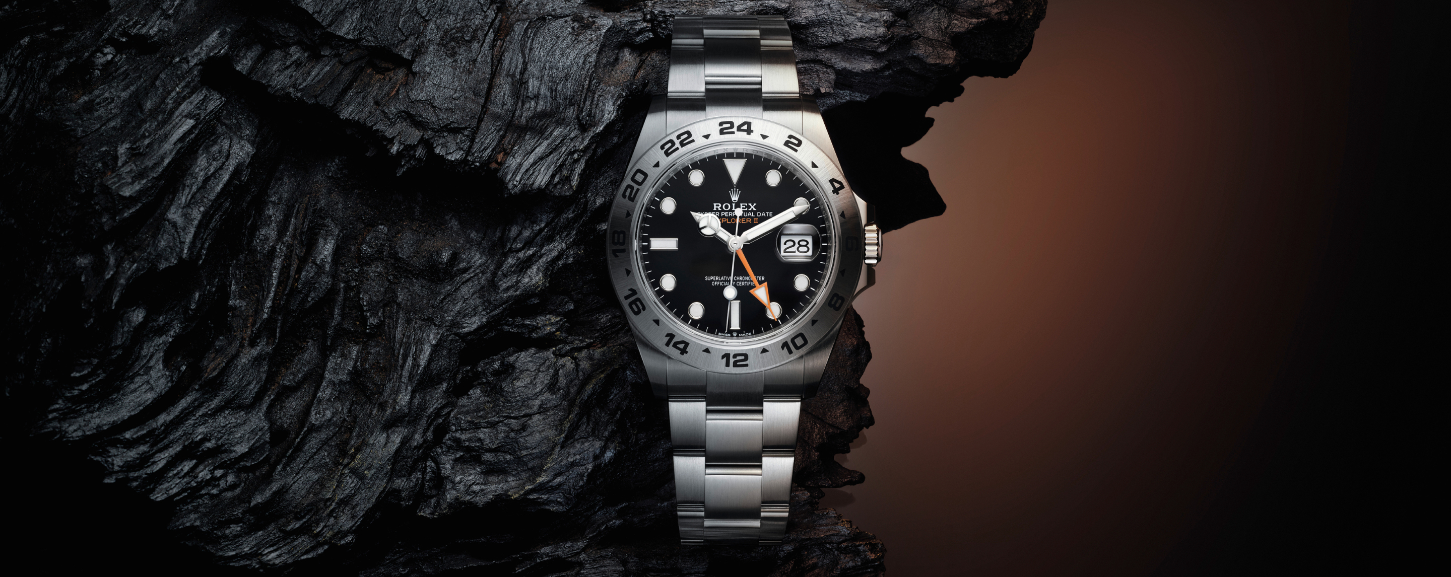 Rolex Explorer II — Schwarzes Zifferblatt auf dunklem Felsen