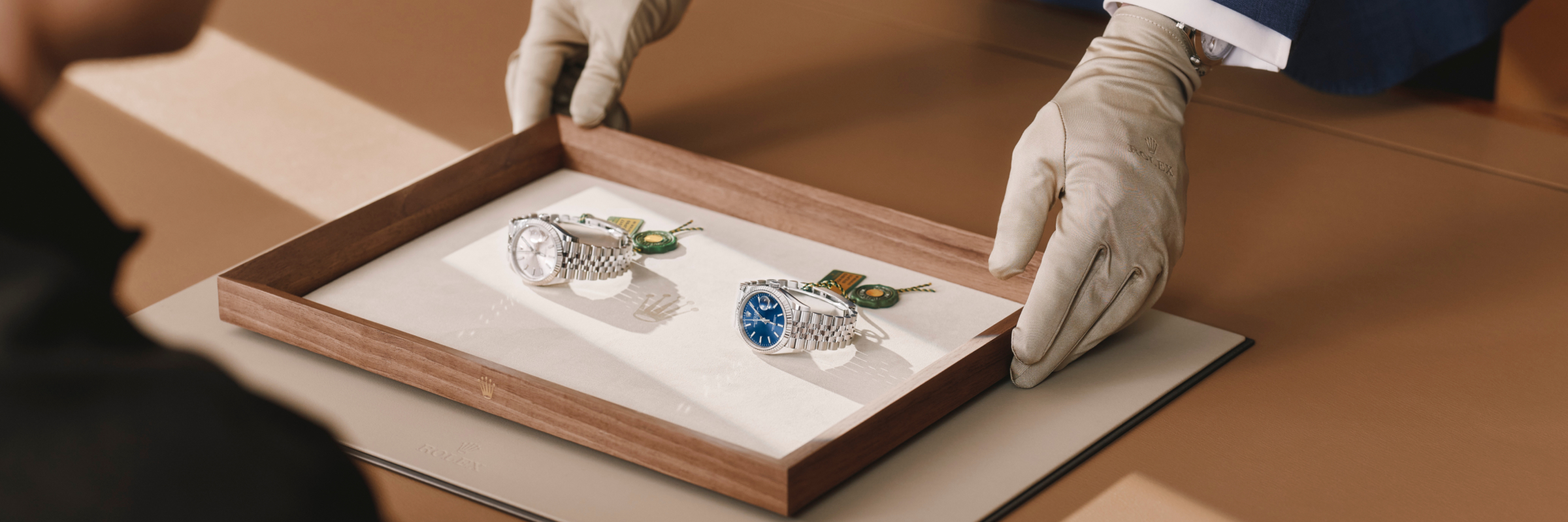 Persönliche Kundenberatung — Rolex Modelle auf Präsentationstablett
