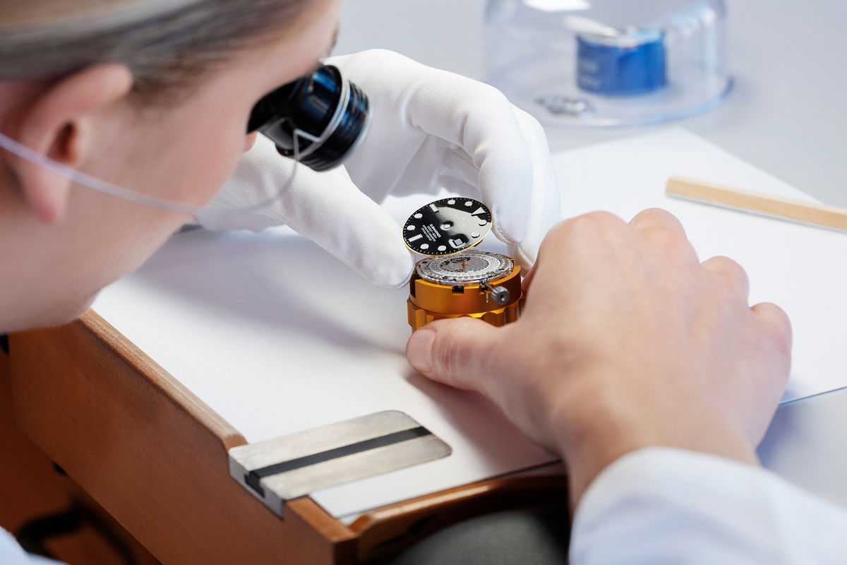 Rolex Uhrmacherin bei der Endmontage eines Uhrwerks